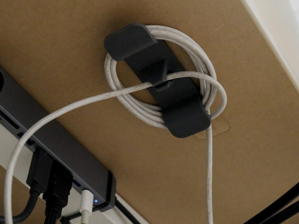 Cable organizer holding coiled cord under a desk